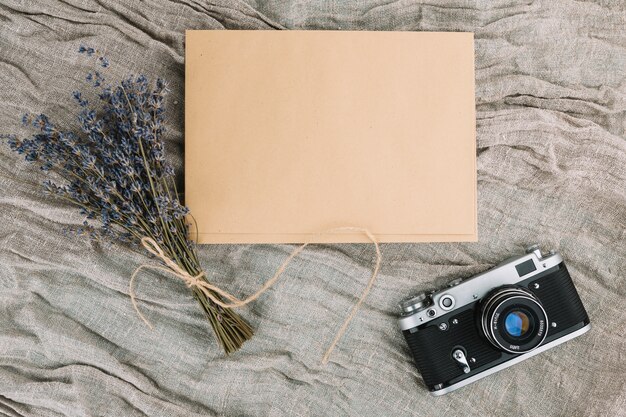 Camera met blanco papier en violet boeket