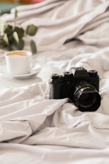 Gratis foto camera op bed en koffiekopje