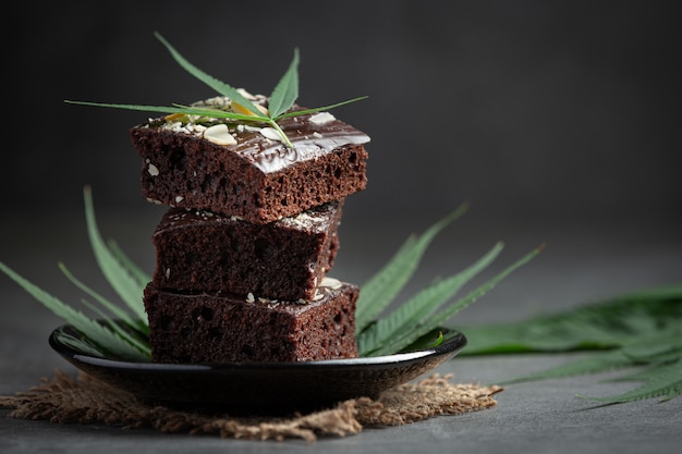 Cannabis brownies en cannabisbladeren op een zwarte plaat