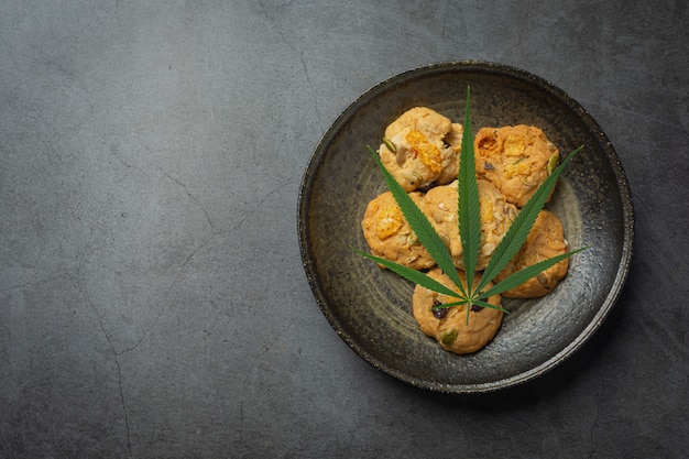 Cannabiskoekjes en cannabisblad op zwarte plaat