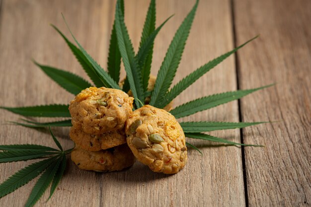 Cannabiskoekjes en cannabisbladeren op houten vloer