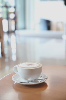 Cappuccino of latte art koffie gemaakt van melk op de houten tafel in de coffeeshop