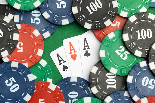 Casinofiches op groene achtergrond met aaskaarten