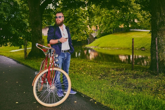 Casual bebaarde man in een park praat via slimme telefoon.