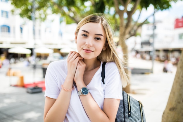 Cclose-up portret van mooie jonge vrouw kijken camera aanraken van de kin met de hand buitenshuis