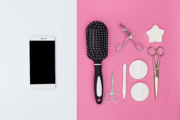 Cellphone en cuticula; haarborstel; schaar; spons; wimperkruller en spons op dubbele achtergrond