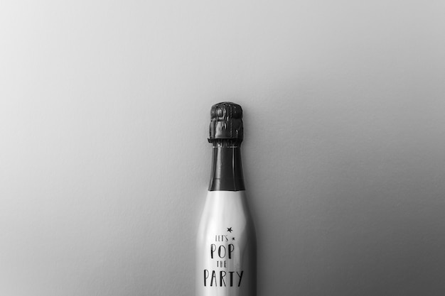 Gratis foto champagne-fles op grijze achtergrond