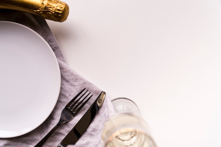 Gratis Foto champagnefles en glas met lege plaat op witte achtergrond