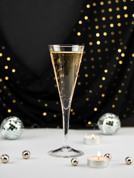 Gratis foto champagneglas met bollen en kaars