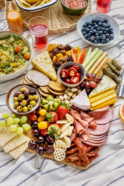 Charcuteriebord met vleeswaren, vers fruit en kaas op een picknickdoek