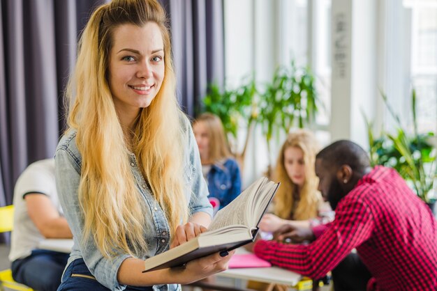 Charmant meisje met boek poseren in de kamer