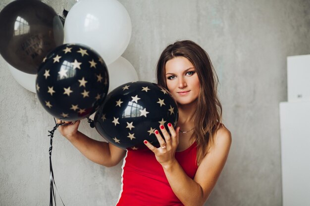 Charmant model in rode jurk poseren met ballonnen