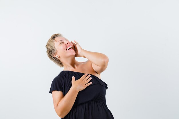 Charmante dame in zwarte blouse die zich voordeed als praten aan de telefoon en spraakzaam op zoek