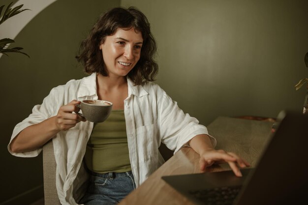 Charmante lachende vrouw met een kopje koffie