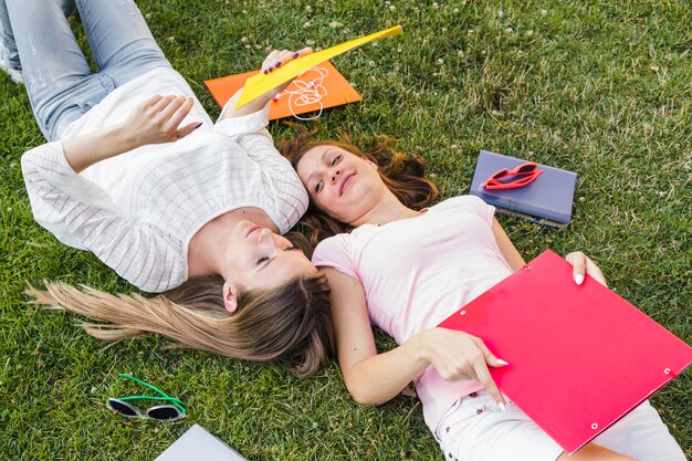 Charmante meisjes poseren met mappen