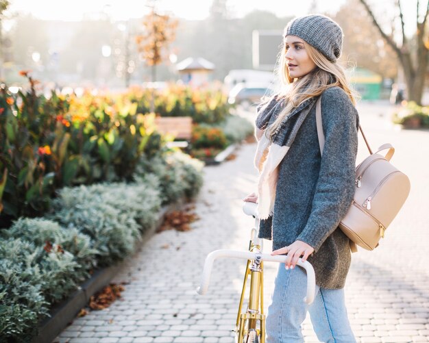 Charmante vrouw met fiets in park