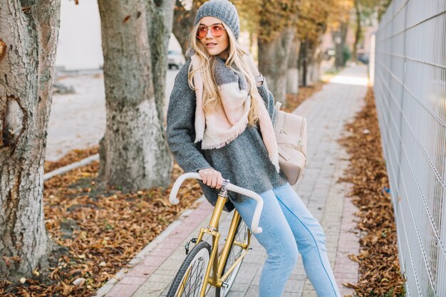 Charmante vrouw op fiets dichtbij omheining