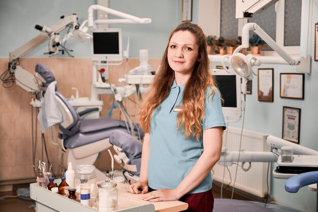 Charmante vrouwelijke tandarts die zich in stomatologiekabinet bevindt
