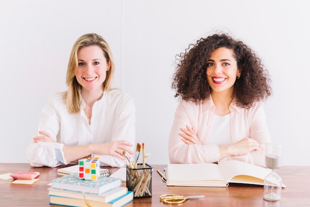 Charmante vrouwen aan tafel kijken camera