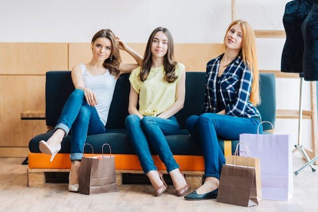 Gratis foto charmante vrouwen op bank na het winkelen