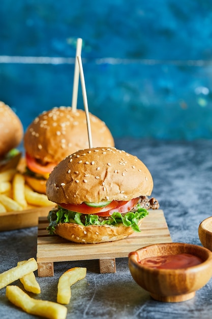 Cheeseburgers met gebakken aardappel op het houten bord