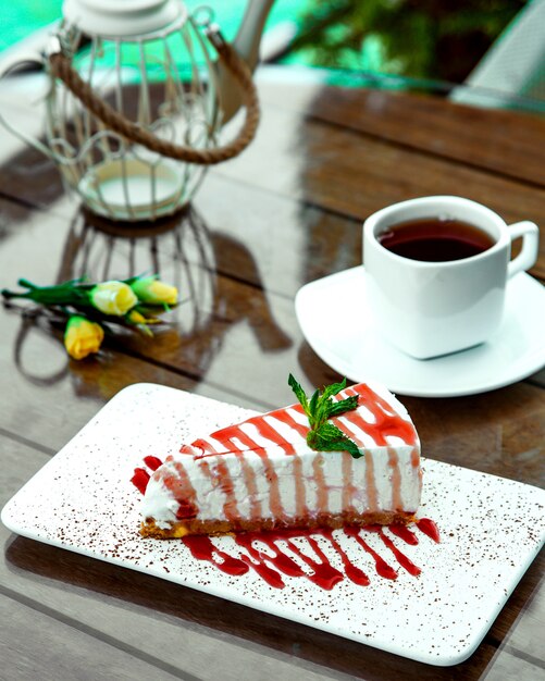 Cheesecake met aardbeien siroop op tafel