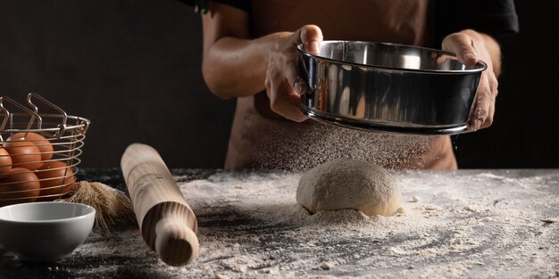 Chef-kok die deeg bedekt met bloem