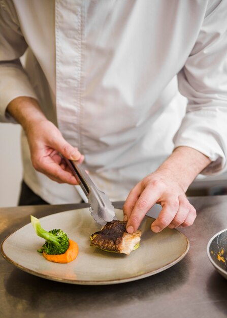 Chef-kok die gebraden vissen vooraanzicht voorbereidt