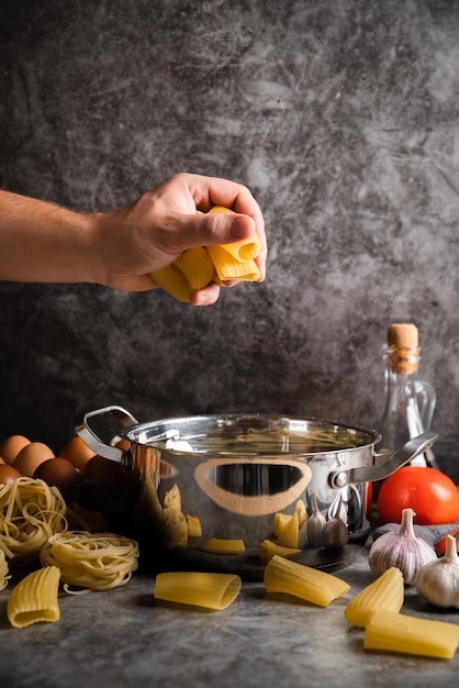 Gratis foto chef-kok die grote gevormde deegwaren houdt