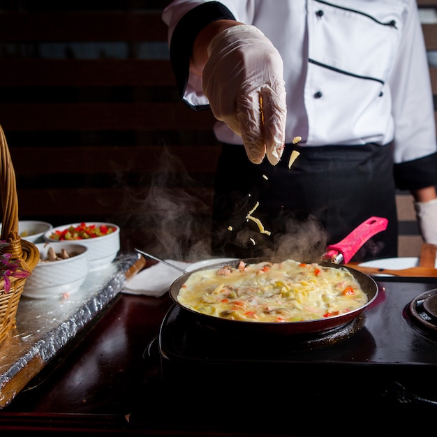 Chef-kok die heerlijke maaltijd in een keuken zijaanzicht voorbereiden