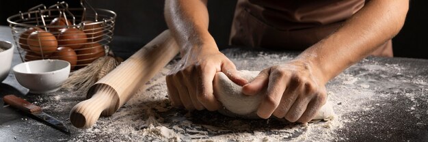 Chef-kok gebruikt handen en bloem om het deeg te kneden