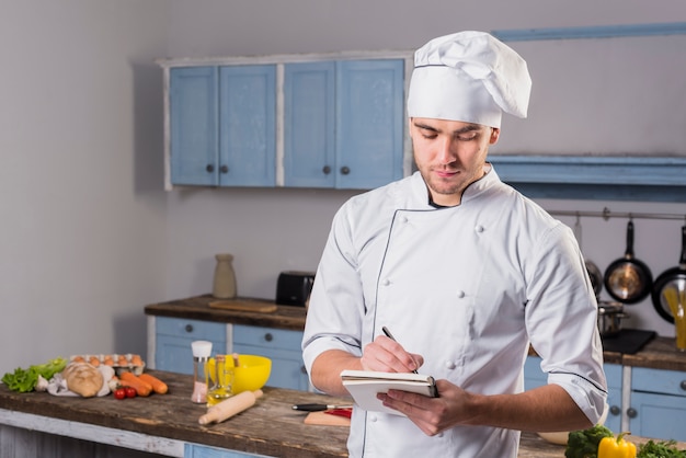 Chef-kok in de keuken maken van aantekeningen