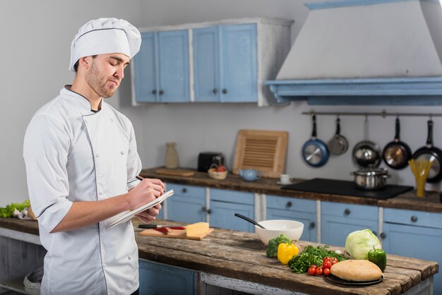 Chef-kok in de keuken maken van aantekeningen