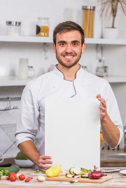 Chef-kok in de keuken toont papieren sjabloon