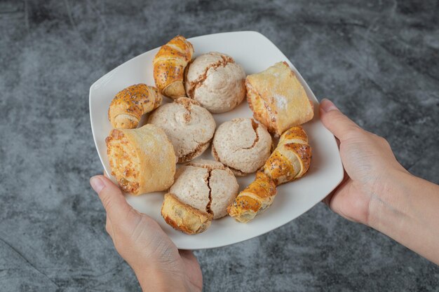 Chef-kok knapperige koekjes met suikerpoeder in de hand houden.