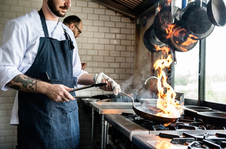 Gratis Foto chef-kok kokend voedsel in de restaurantkeuken