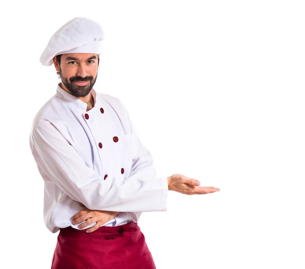 Chef-kok presenteert iets over witte achtergrond