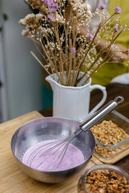 Chia pudding kookproces. Amandelmelk gemengd met natuurlijk roze extract van drakenfruit en chiazaad.