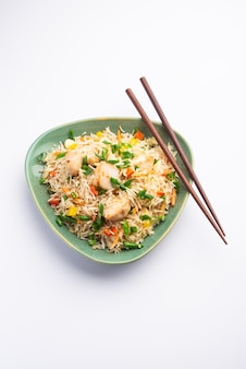 Chicken fried rice is een populair indiaas chinees of indo-chinees straatvoedsel dat wordt geserveerd in een bord met eetstokjes