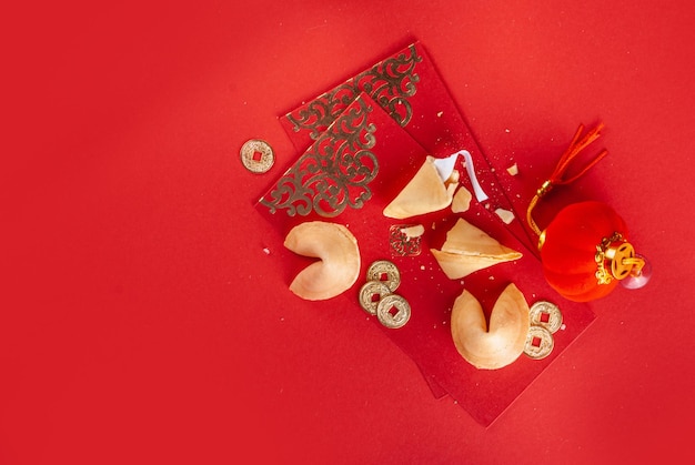 Chinese nieuwe jaarachtergrond. rode en goudgele flatlay met traditioneel chinees nieuwjaarsdecor, enveloppen met wensen, gouden munten, waaiers, chinese lantaarns, sinaasappels en thee