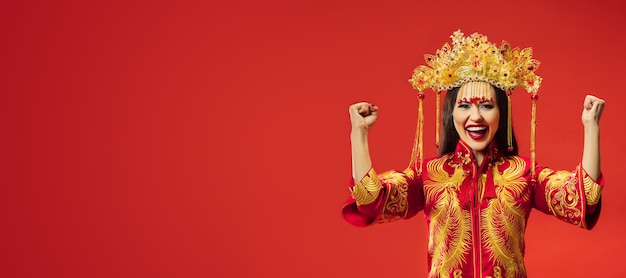 Chinese traditionele bevallige vrouw bij studio over rood.