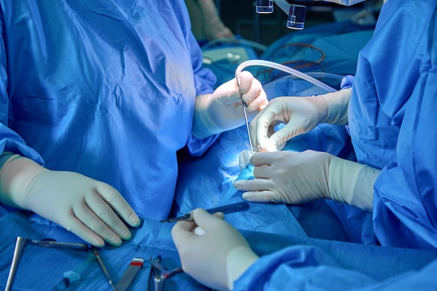 Chirurg en zijn assistent uitvoeren van cosmetische chirurgie op neus in ziekenhuis operatiekamer.