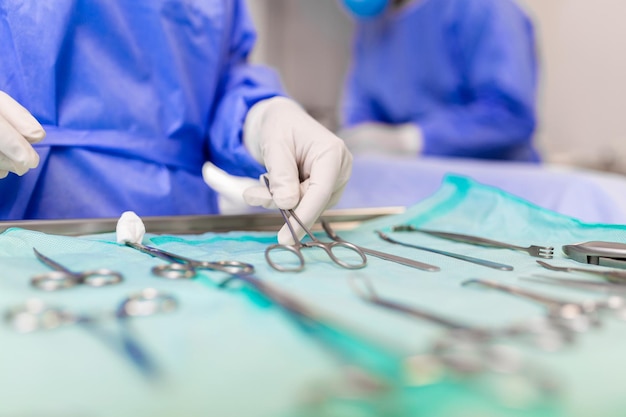 Chirurg pakt chirurgisch gereedschap uit dienblad Chirurg bereidt zich voor op operatie in operatiekamer Hij is in een ziekenhuis