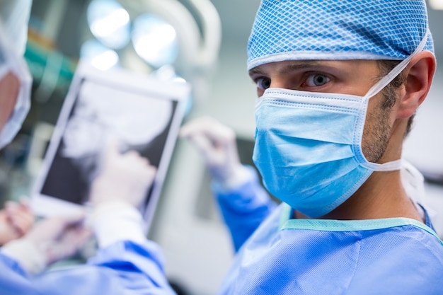 Chirurgen bespreken op de patiënt x-ray in operatiekamer
