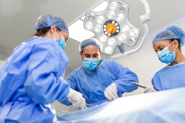 Chirurgen die operaties uitvoeren in operatiekamer Mannelijke en vrouwelijke chirurgen die patiënt opereren Medische professionals dragen scrubs