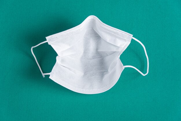 Chirurgisch masker op minimalistische groene achtergrond