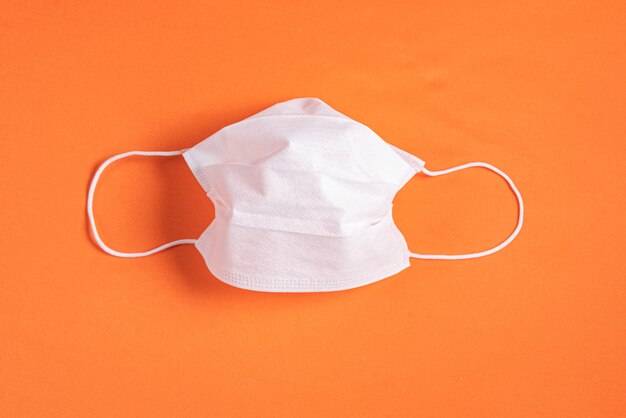 Chirurgisch masker over minimalistische oranje achtergrond