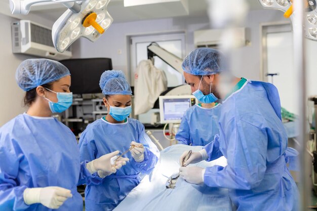 Chirurgische operatie Groep chirurgen in operatiekamer met chirurgische apparatuur Medische achtergrond selectieve focus Chirurgenteam werkt samen tijdens operatie