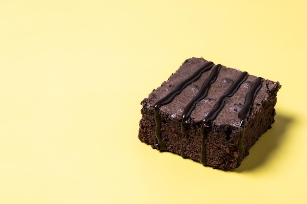 Gratis foto chocolade brownie gedeelte op gele achtergrond