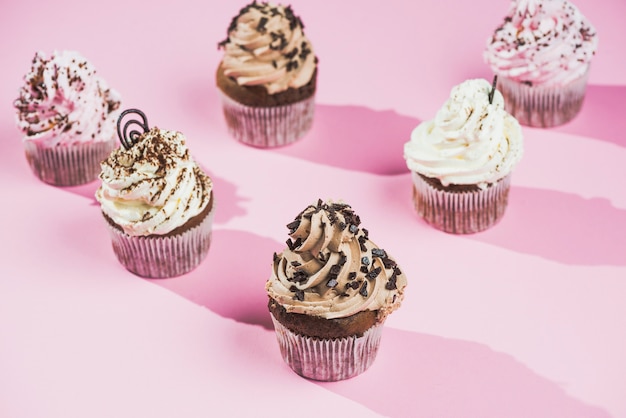 Chocolade cupcake met werveling van de chocolade de boteroom op roze achtergrond